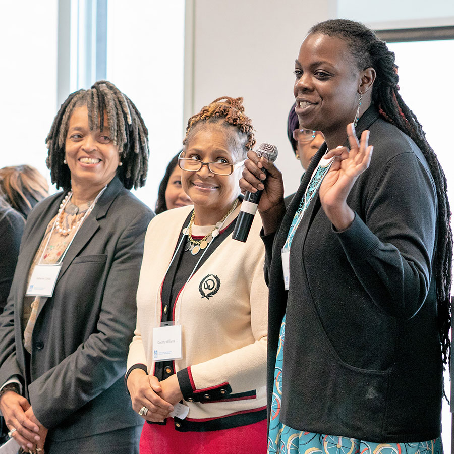 women of color speaking at a conference