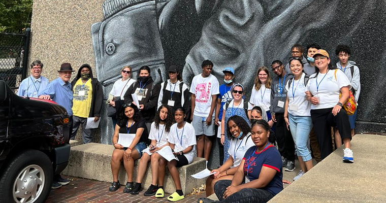 Summer program poses for a photo by a Mel King mural