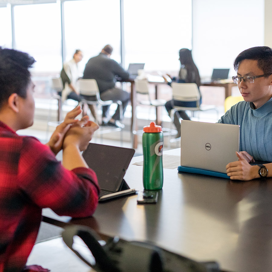 entrepreneurs in Venture Development Center at laptops with water bottles