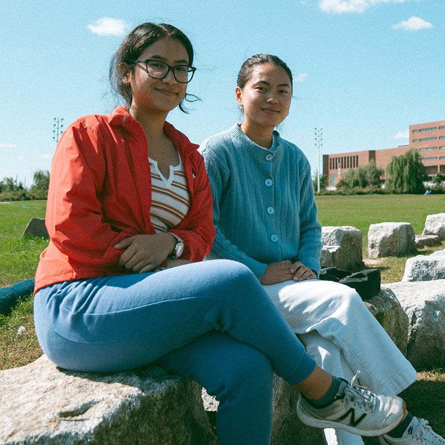 two students sitting on campus circle