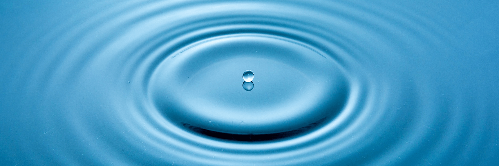 Droplet of water ripples the surface
