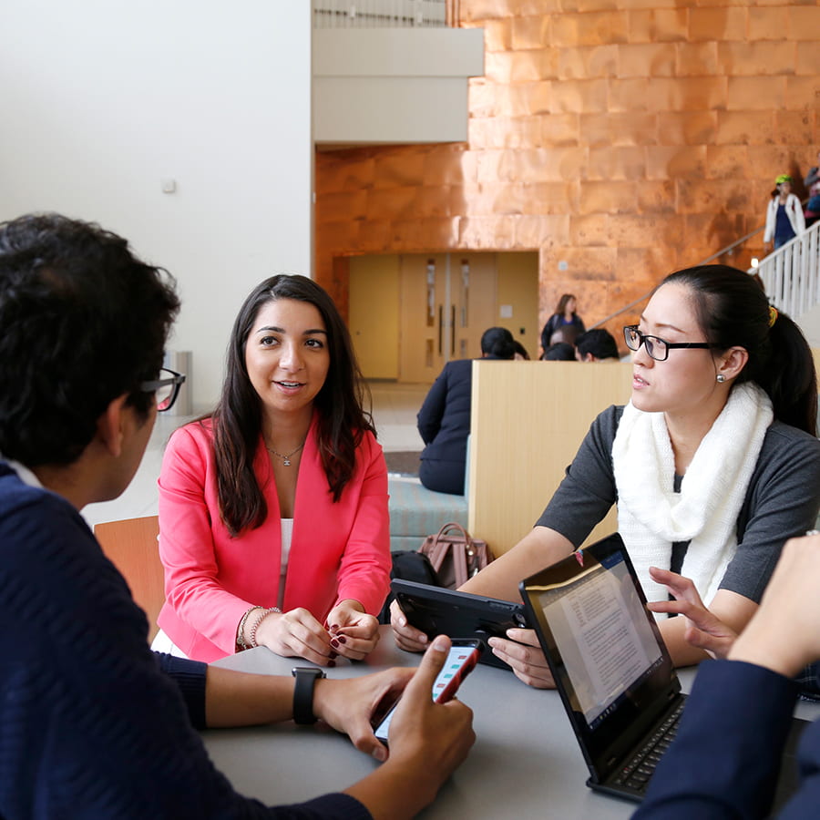 Group of business students meet at table in University Hall.