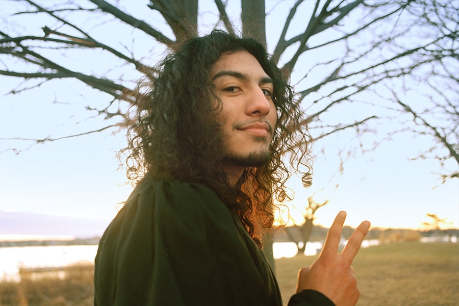 Student makes peace symbol with hand facing camera.