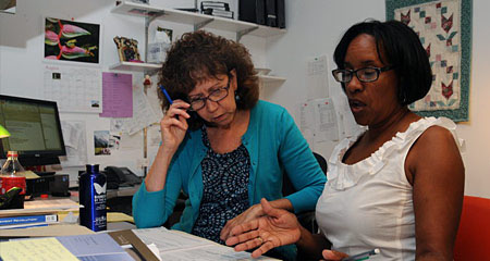 A Pension Action Center attorney and volunteer counselor discuss a case.