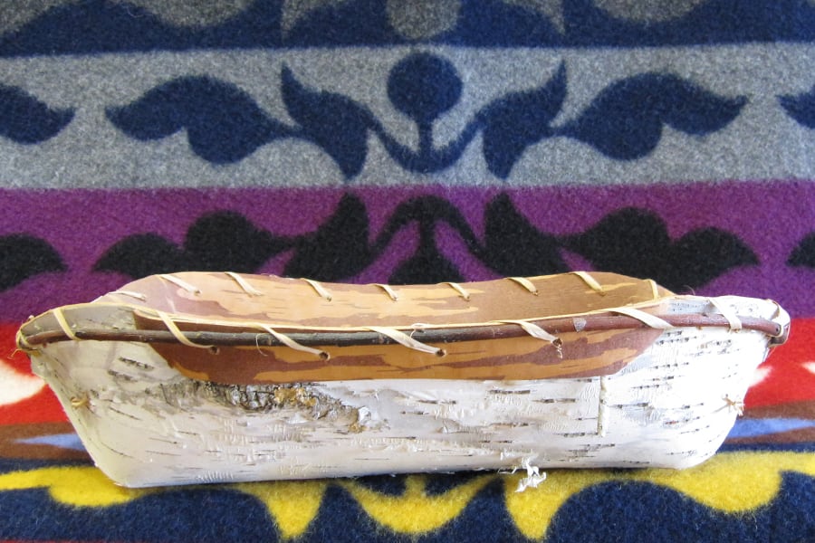 Wooden vessel sitting on Native American blanket