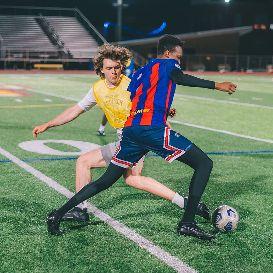 Two students play soccer.