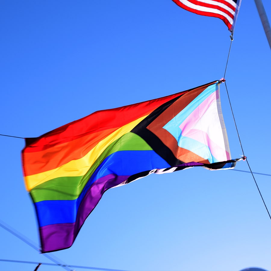 Pride flag with corner USA flag shows in back.