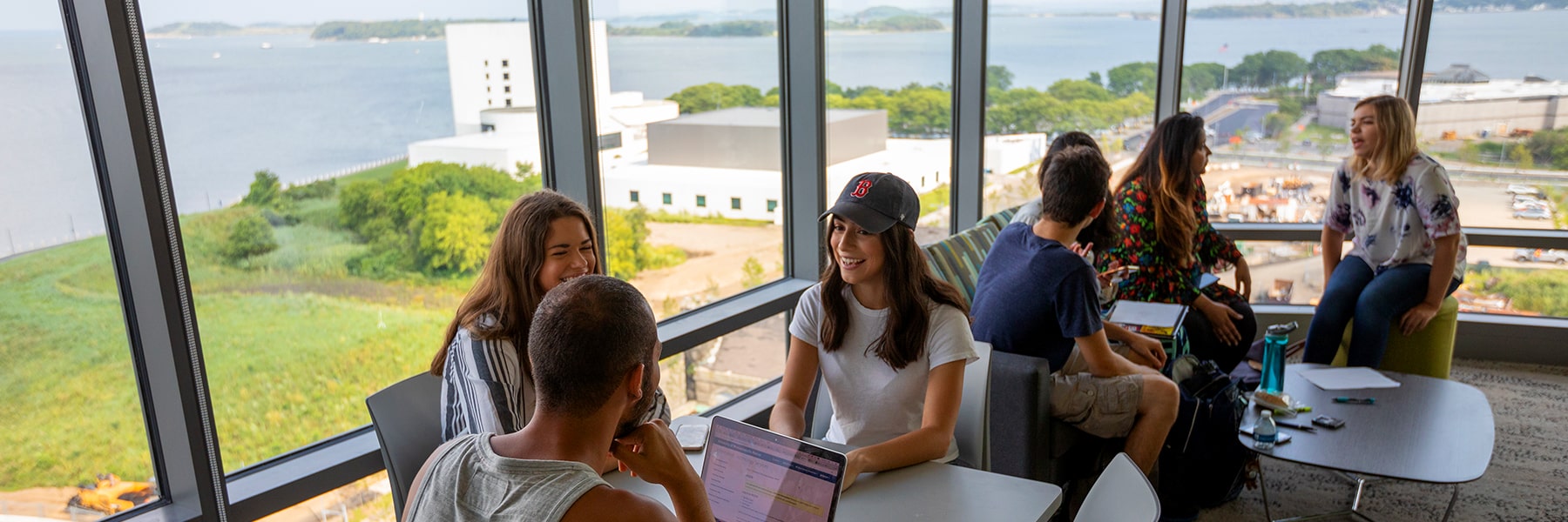 Students in Residence Hall Lounge with view of the water.