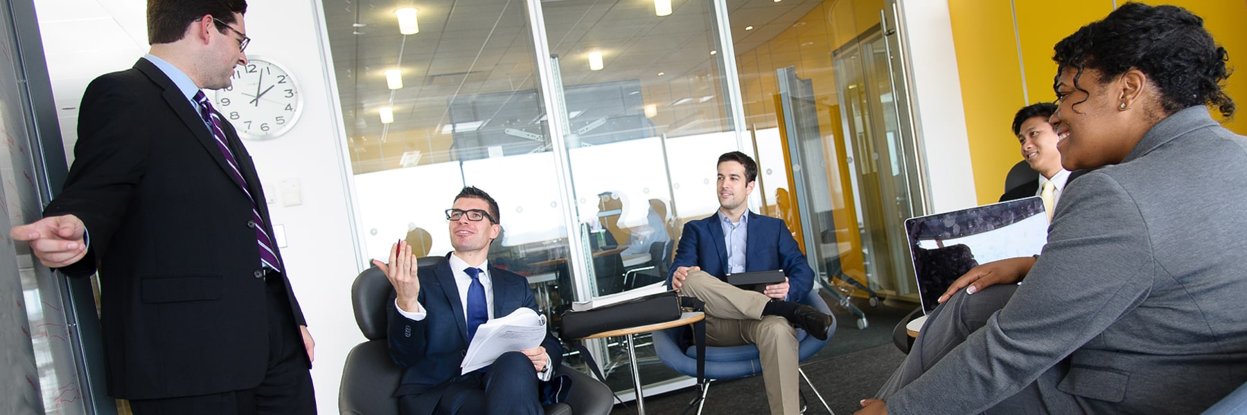 people in business suits talking in the UMass Boston Venture Development Center