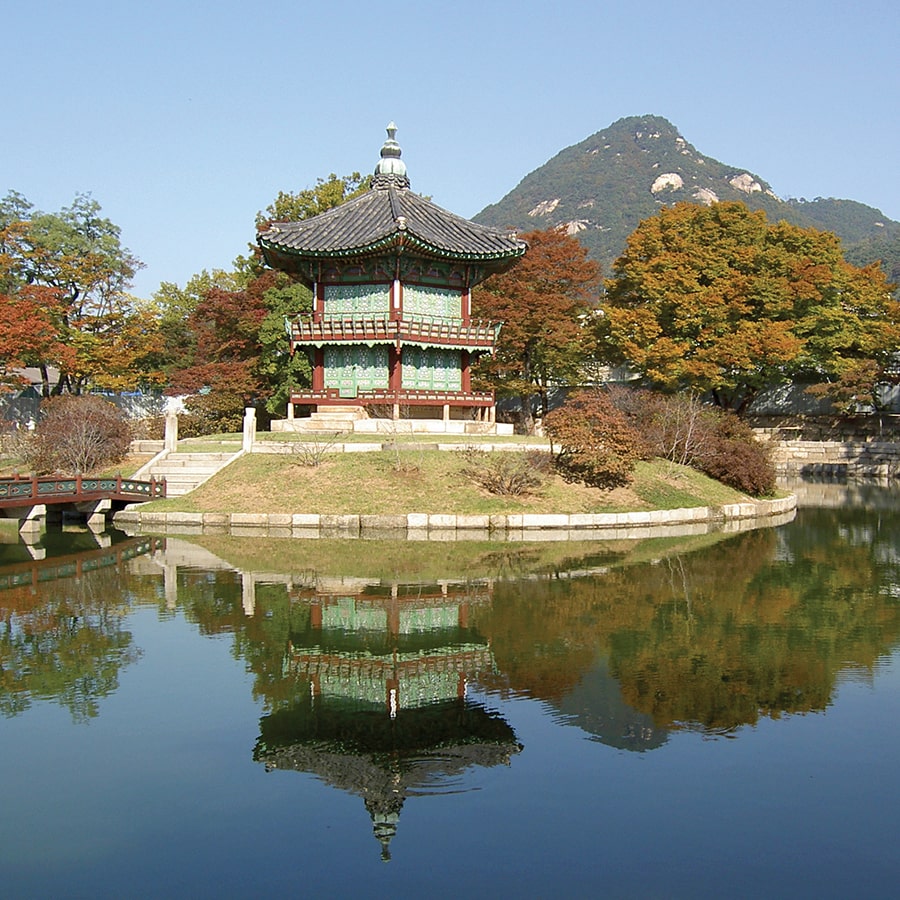 A Korean temple with mountain backdrop.