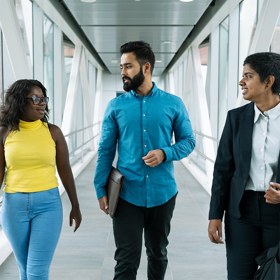 three students walking in catwalk, tallest in center