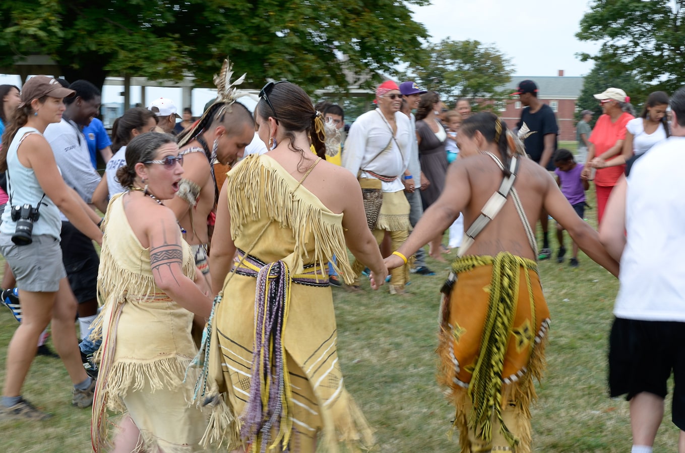 Group demonstrating a tribal dance with visitors