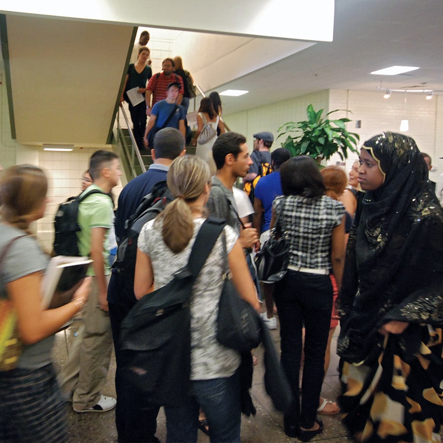 Crowd of students walk in hallway.