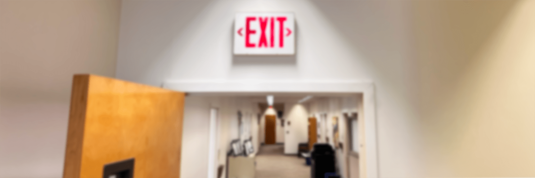 Blurred image of exit sign in hallway