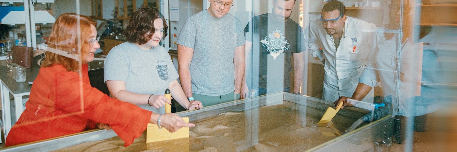Students & faculty work at a water table in the lab.