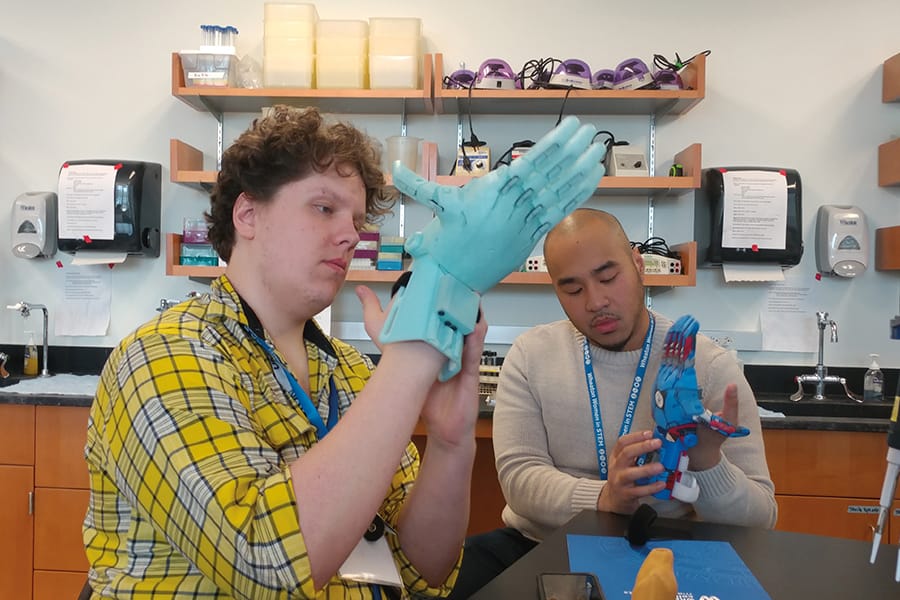 Student tests a 3D printed hand in Makerspace.