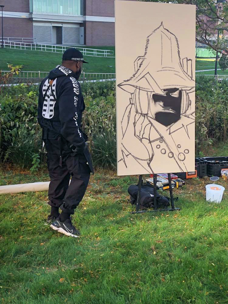 ProBlak paints a mural behind University Hall. 