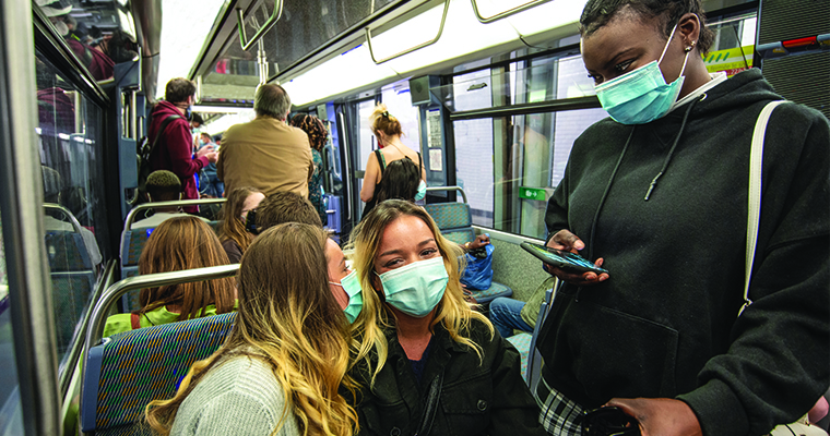 Students wearing masks on a train. 