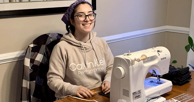 KT Taylor, '23, using one of six donated sewing machines to make PPE for local health care workers