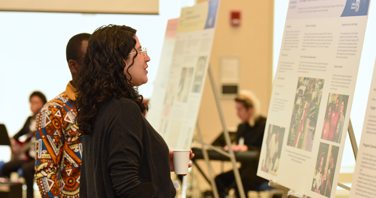 Attendees look at community-engaged project posters.