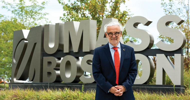 Chancellor Marcelo Suárez-Orozco outside the UMass Boston sign in front of the dorms