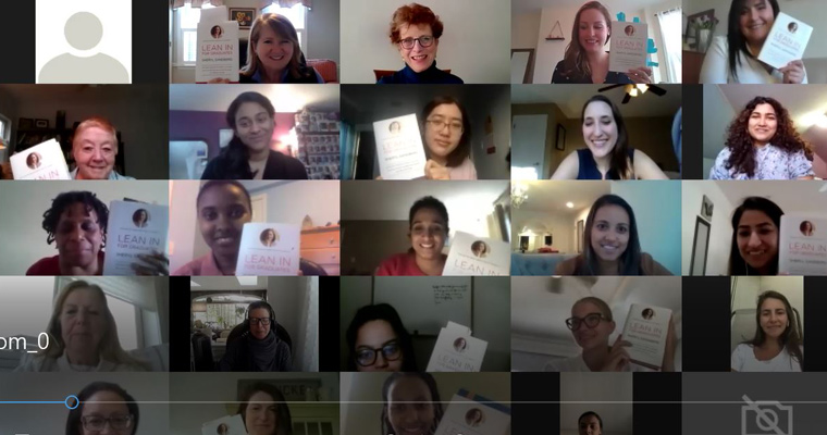 A screenshot of a virtual conference showing about 20 women holding up a book. 