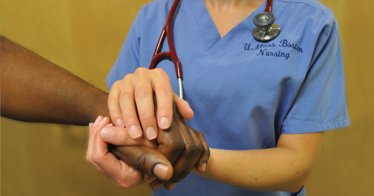 UMass Boston student nurse's hand clasped on top of a Black hand