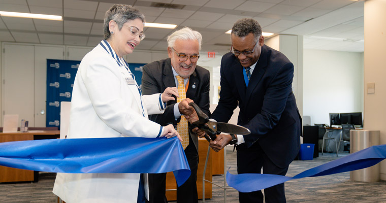 Vice Chancellor for Student Affairs Karen Ferrer-Muñiz, Chancellor Marcelo Suárez-Orozco, and Assistant Vice Chancellor Steven Neville cut t 