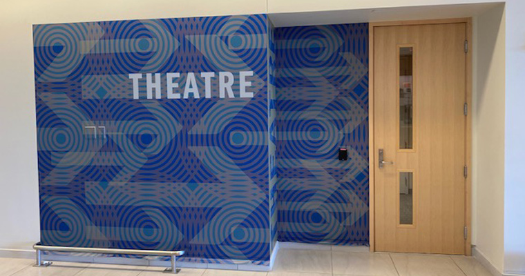 Blue sign in U Hall that says Theatre