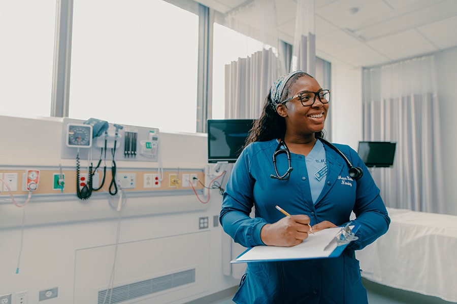 nursing student with clipboard and monitoring devices