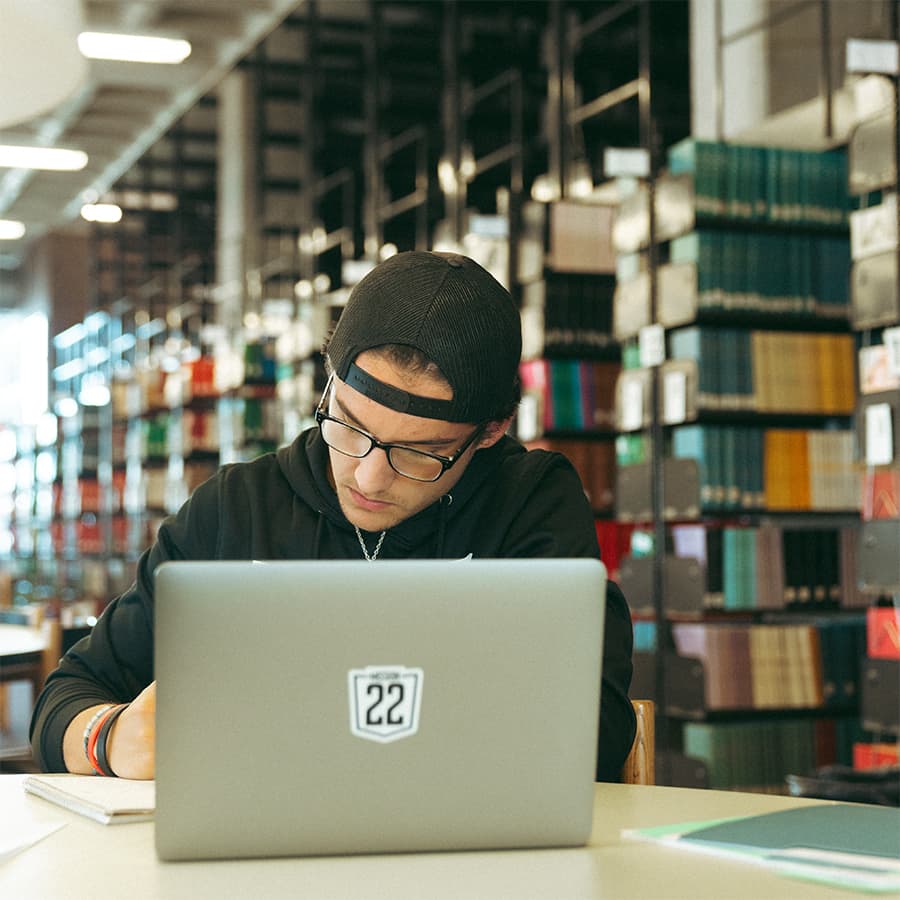 Student on laptop studying in the library.