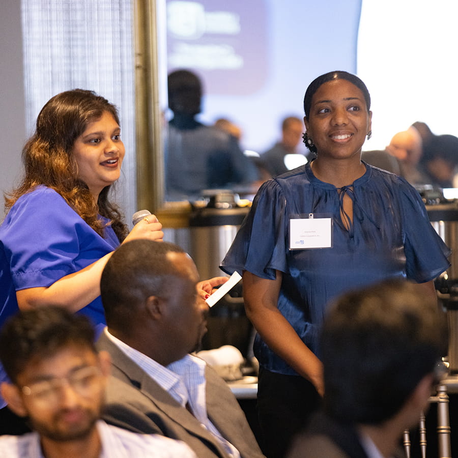 student awaits chance to speak at Best Boston Program with moderator holding  with microphone
