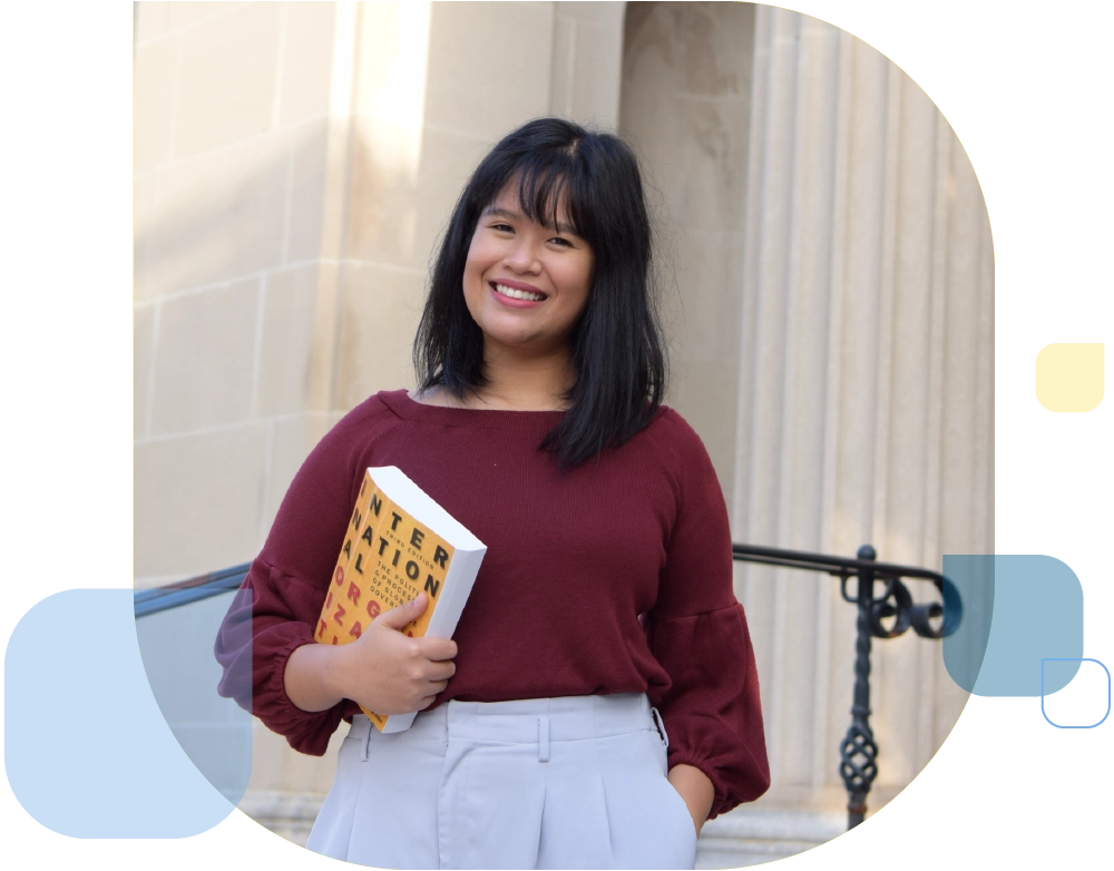 conflict resolution student holding book on international relations in front of government building
