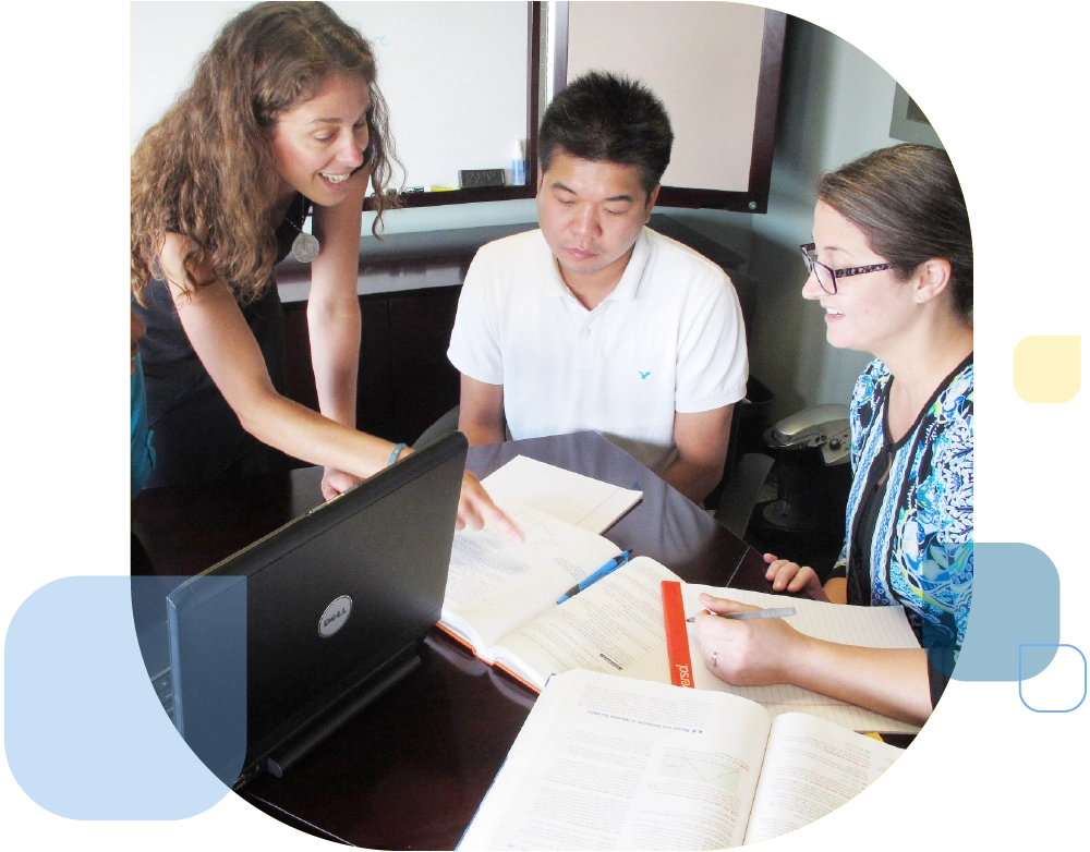 3 faculty members in the MPA program having a discussion with program names and interconnecting arrows on whiteboard in the background