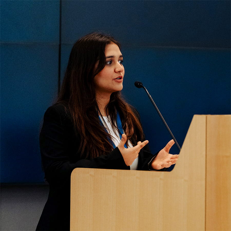 Graduate student presenting at a wooden podium.