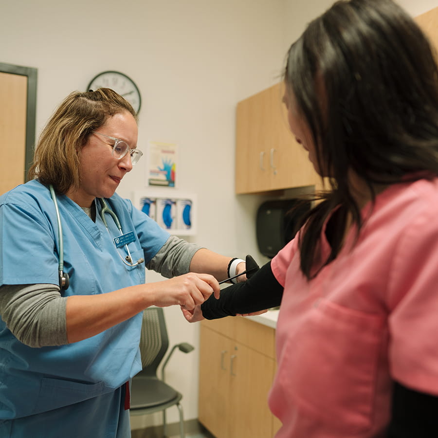 nurse practitioner using a blood pressure cuff on person's arm