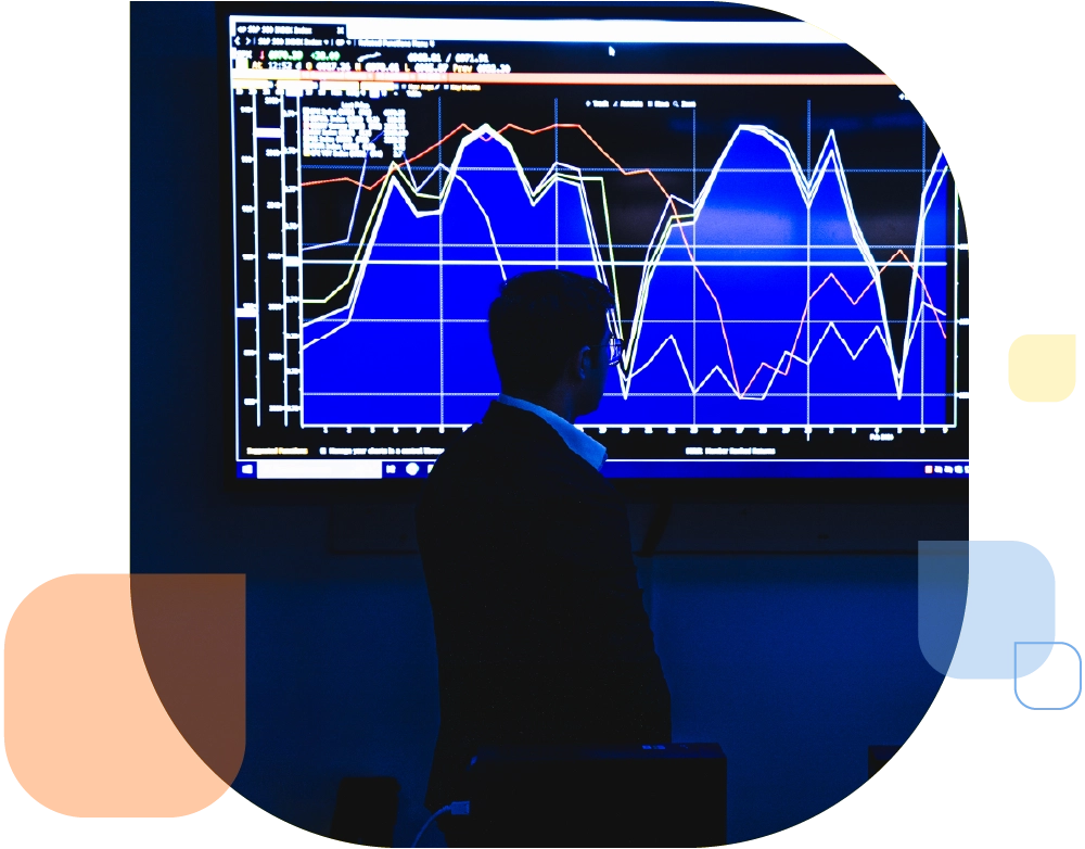 man in business suit stands in front of data chart illuminated bright blue hues