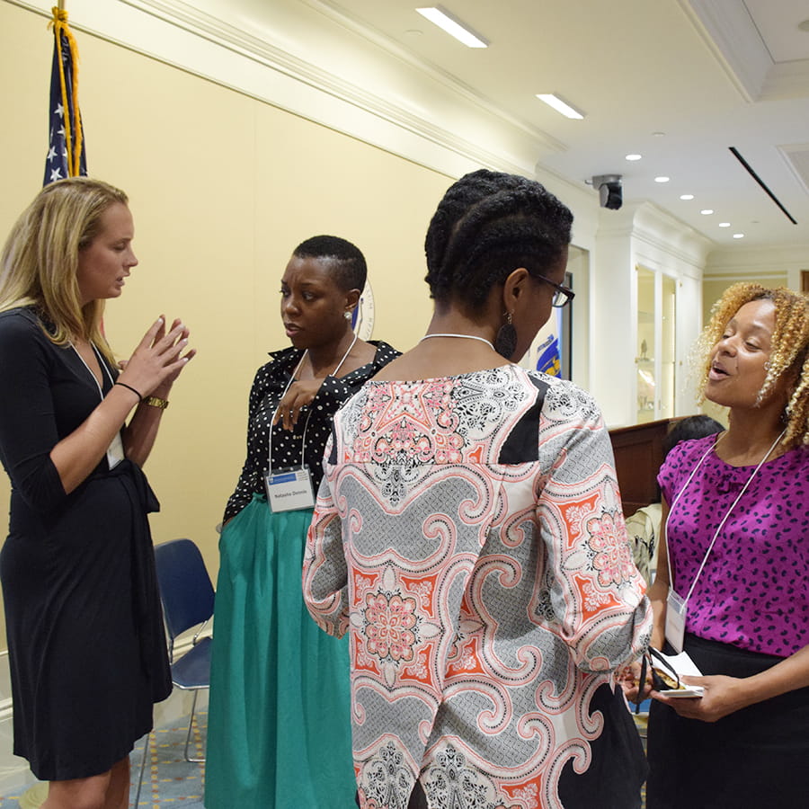 women at the Boston State House discussing in hallway
