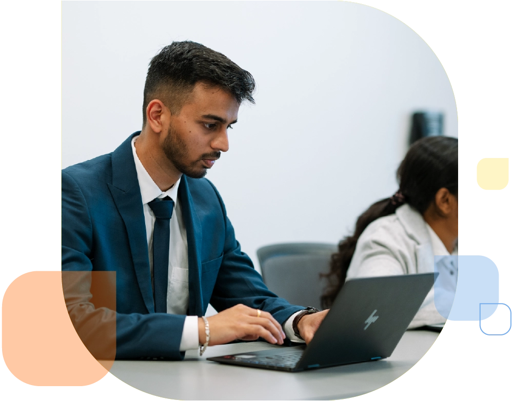 college of management students in business attire on laptop