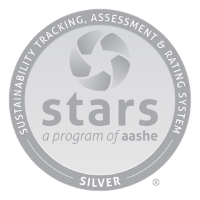 Silver Colored Round Badge for the Sustainability Tracking Assesment Rating System. Around the circile is written American Association of Sustainability in Higher Education