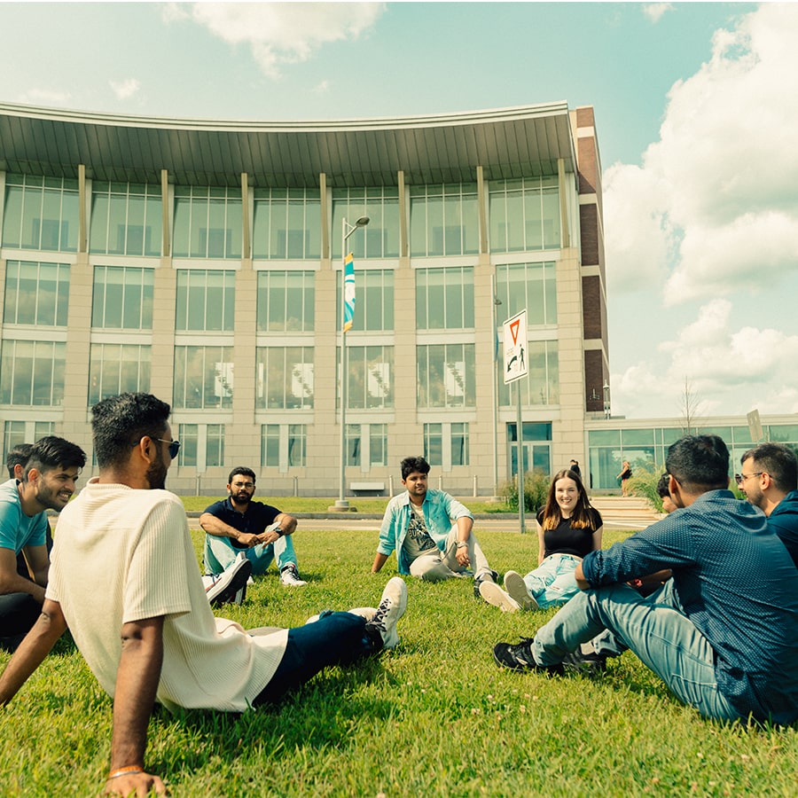 Students sit in circle on Campus Center Lawn.