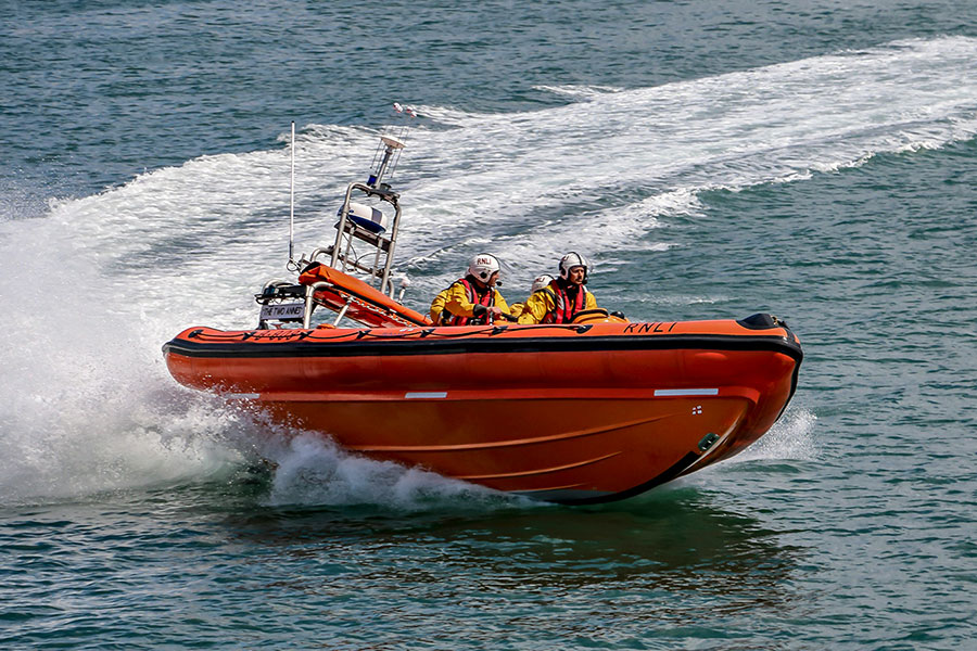 Coast guard riding in an orange boat at sea