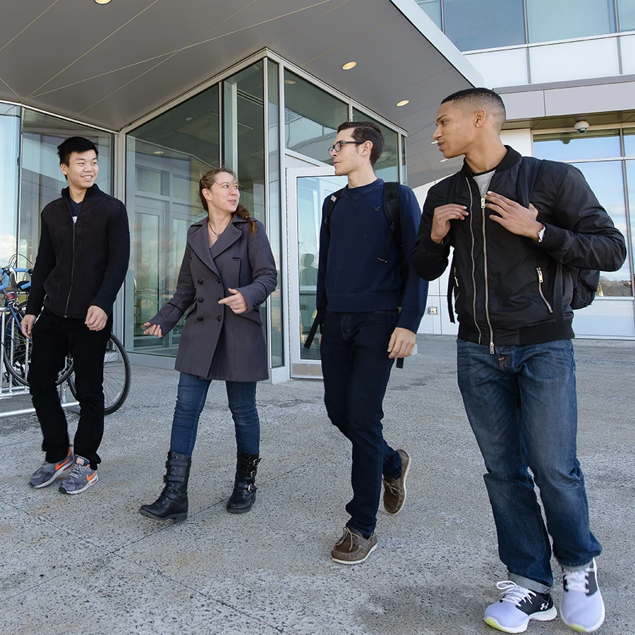 4 students walk outside the Integrated sciences complex.