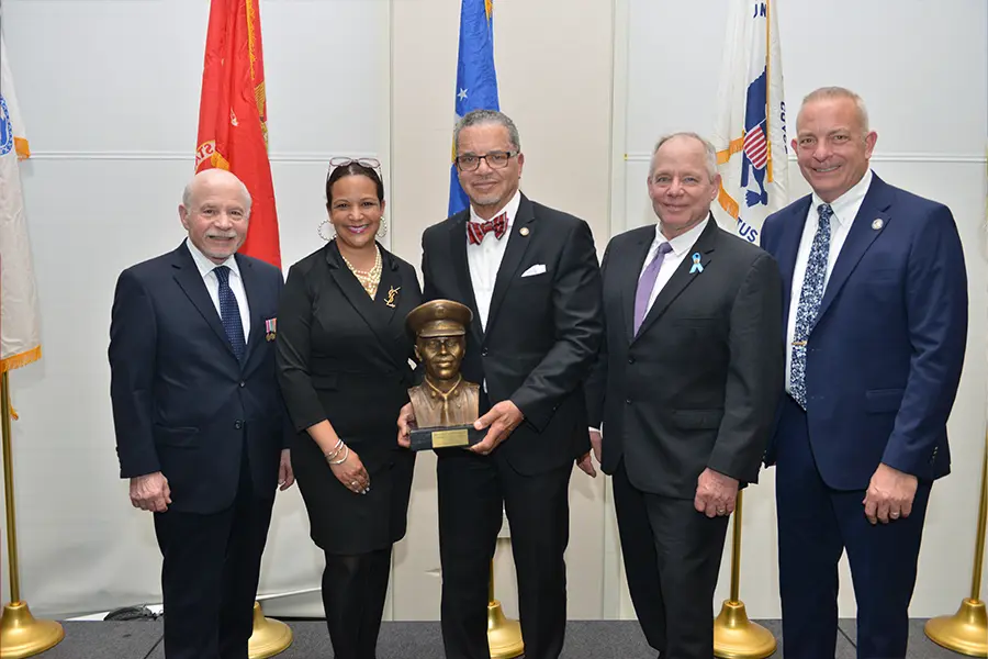 Group of veterans stand with award.