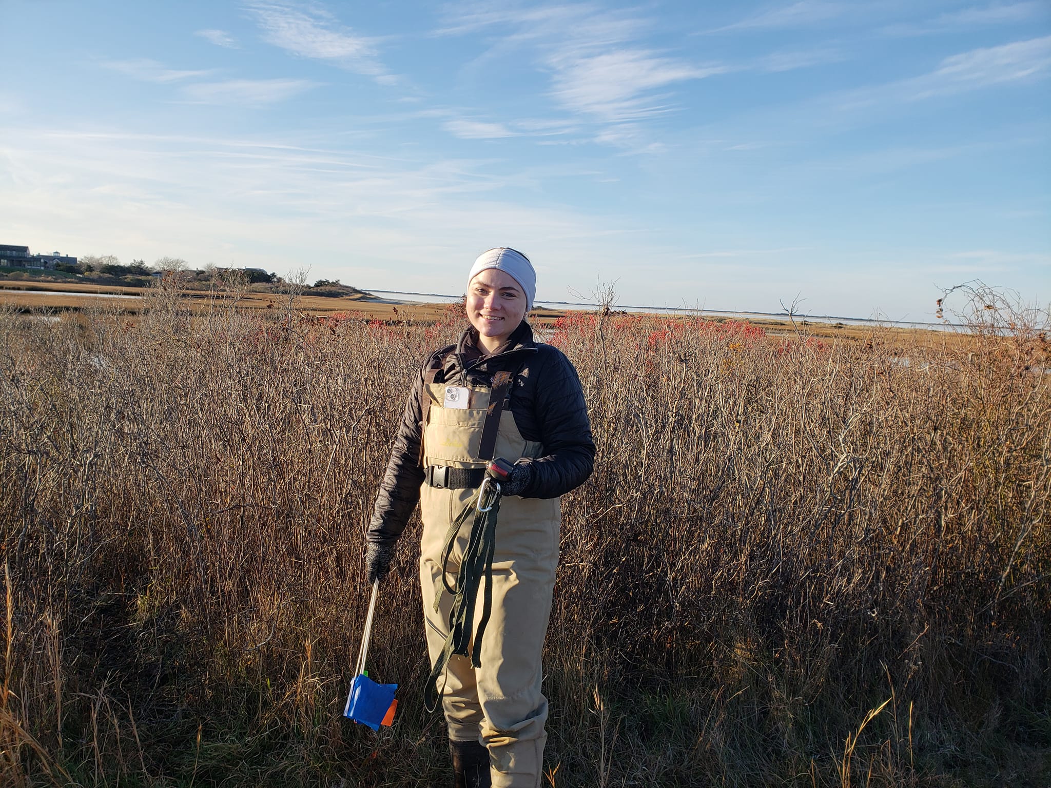 student in waders in the winter marsh