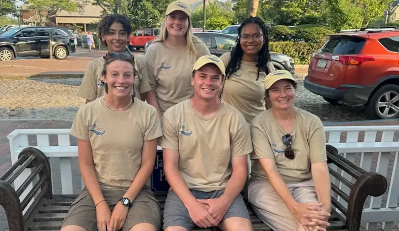Summer 2025 in Nantucket Field Station t-shirts & hats pose for photo outdoors,