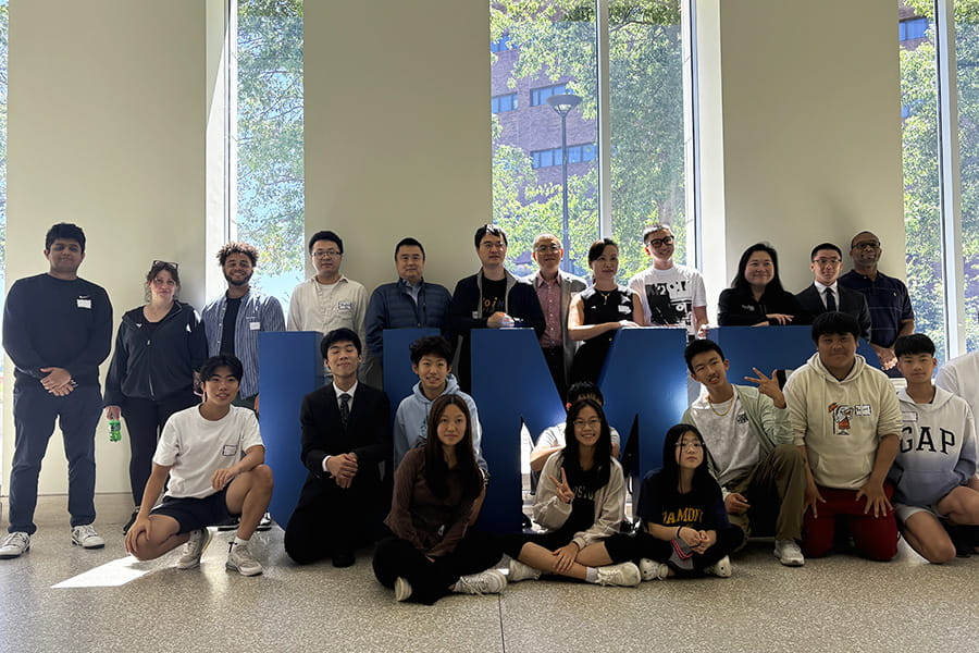 A group of students from the AI In ONE Day program, gathered in the UMass Boston campus center