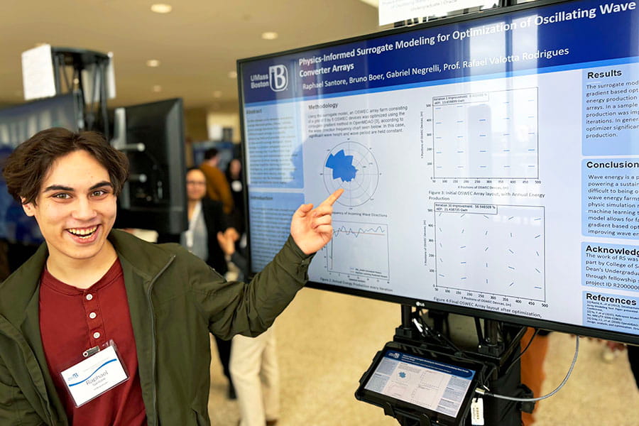 Raphael Santore, a UMass Boston student, shows off his poster at the 2026 CSM Showcase