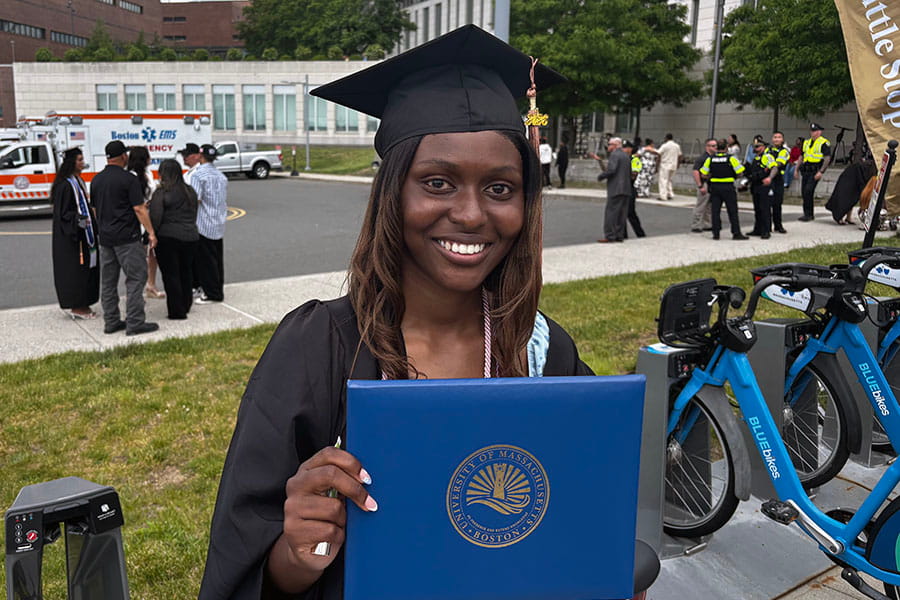Ashanti Mclane, a 2026 graduate, poses after graduating near the shuttle pickup stop