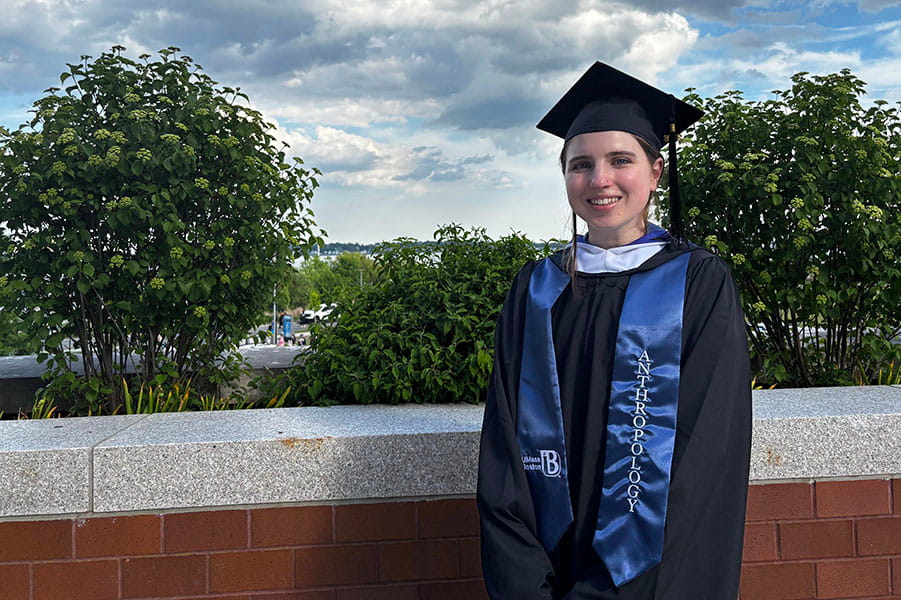 Claire Ross, a 2026 MS graduate, stands by a low wall outdoors